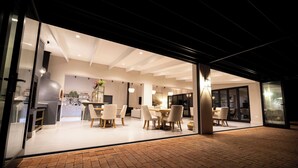 An open-plan modern kitchen and dining area with a brick floor, large windows, and contemporary furniture. - Diggers Country House (Tulbagh)