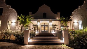 A building with a grand entrance, a staircase, and a well-lit facade. - Diggers Country House (Tulbagh)