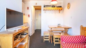 A cozy room with a TV, wooden furniture, a small table, and a bed with a red polka dot cover. - Peaceful Alpine Escape, Risoul (Risoul)