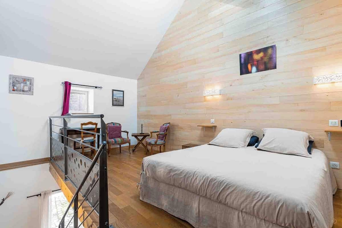 Une chambre à coucher avec un lit, un bureau et deux chaises.