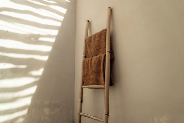 A bamboo ladder leaning against a wall with a brown towel draped over it. - Welly Bungalow (Gili Trawangan)
