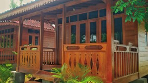 A wooden structure with a porch, windows, and a railing.