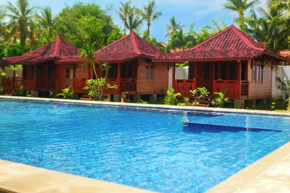 A swimming pool with red-roofed cottages in the background.