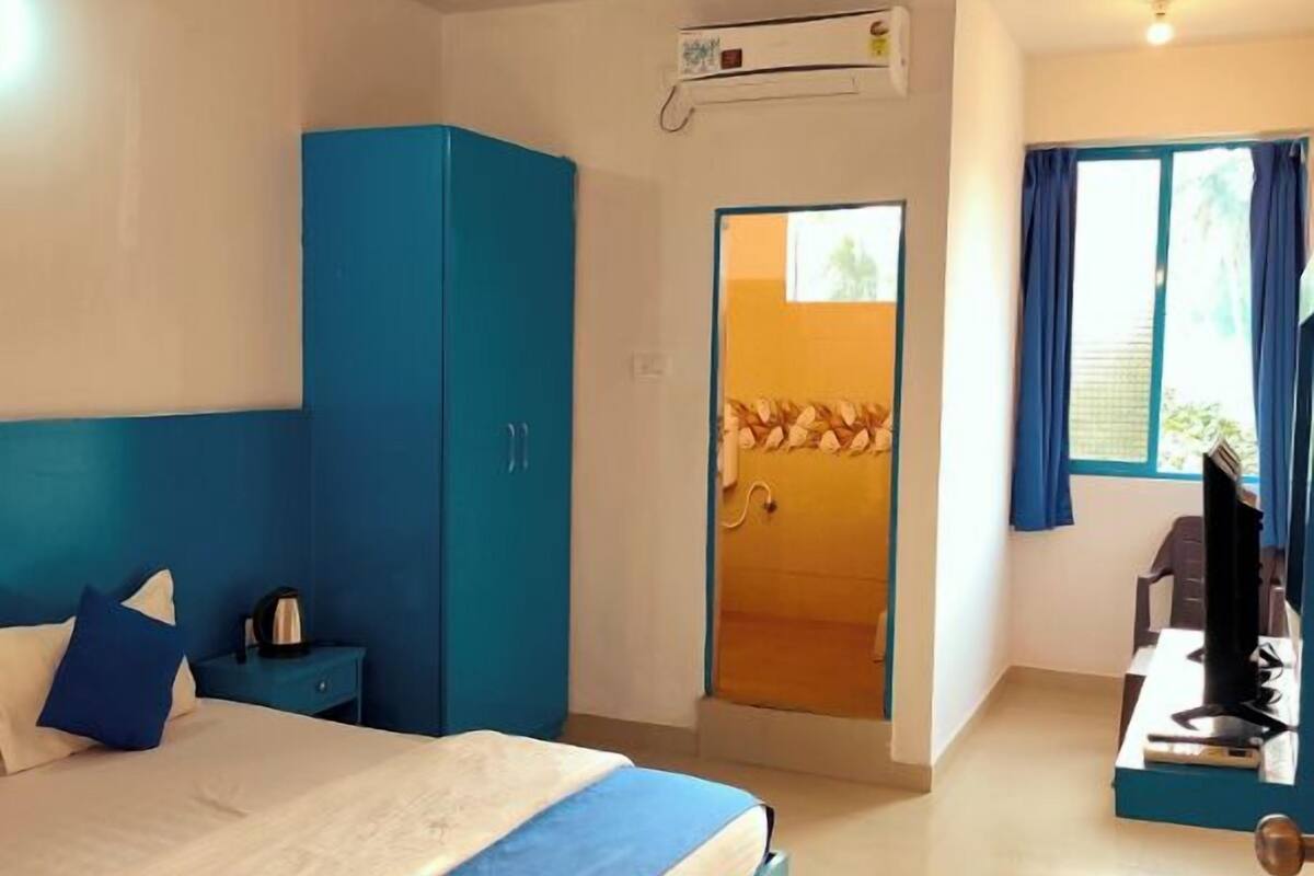 Una camera da letto con un letto, un armadio, una scrivania con un computer e una ventola a soffitto.
