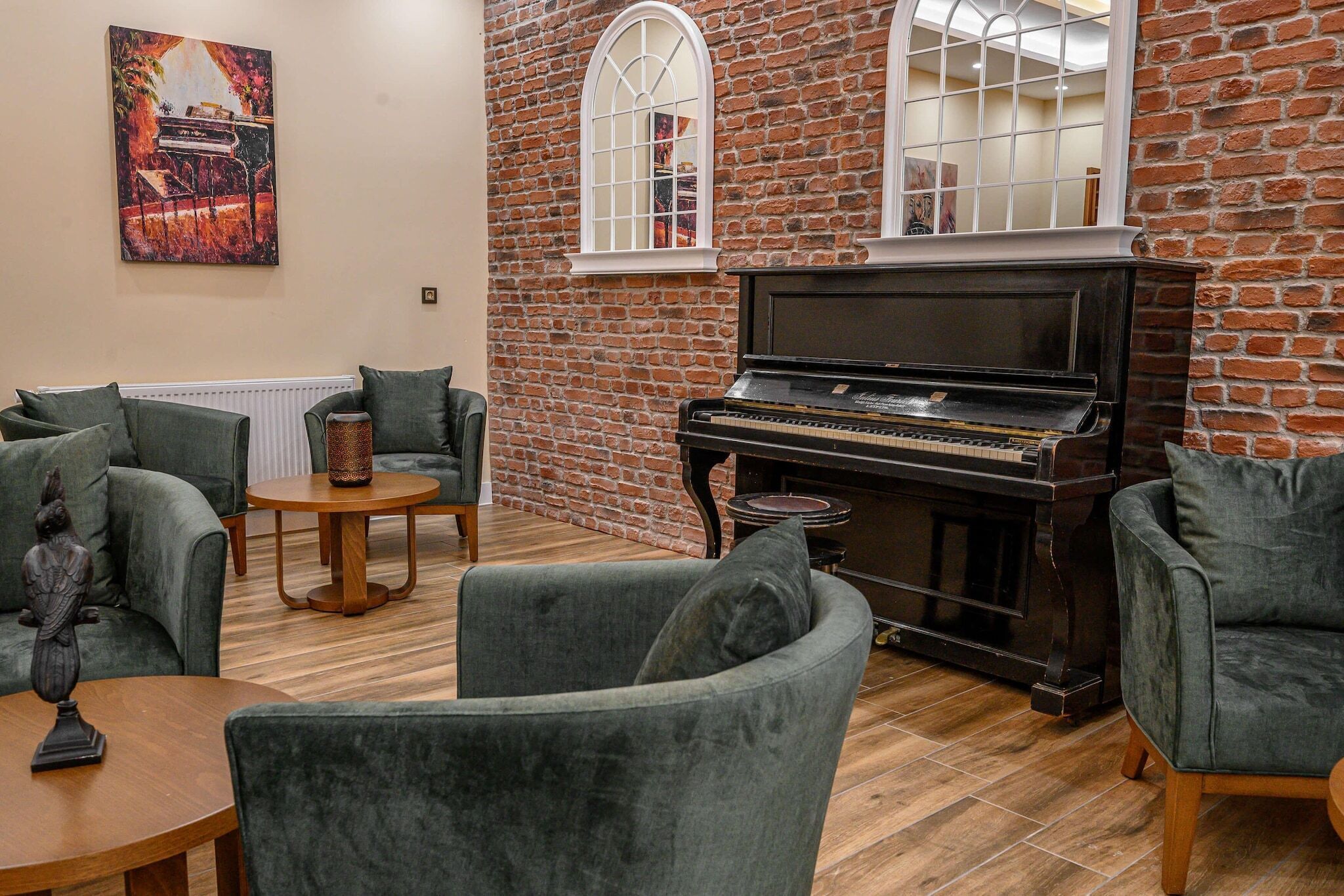 A cozy living room with a grand piano, brick walls, and comfortable seating.