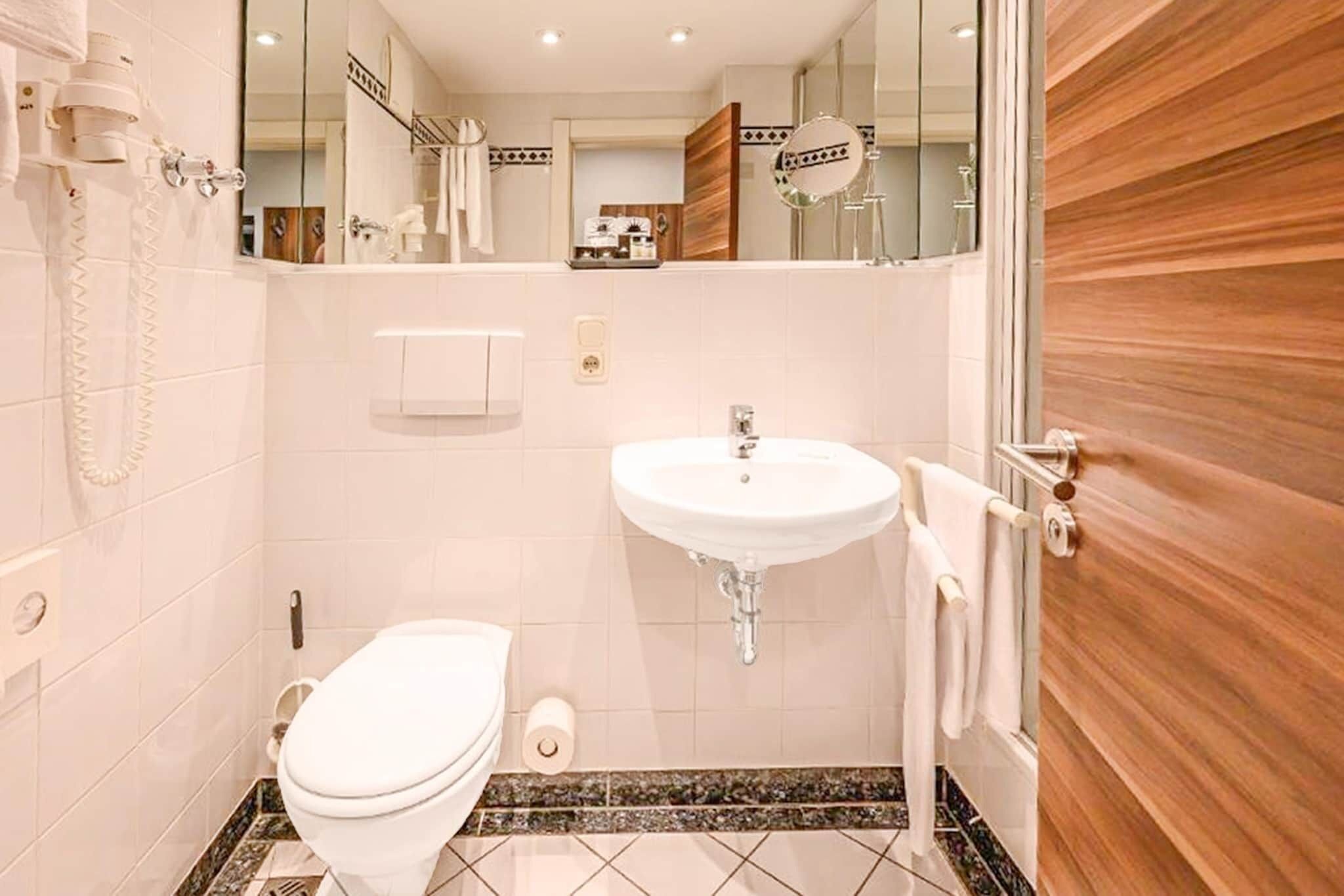 Ein Badezimmer mit Toilette, Waschbecken und Spiegel.