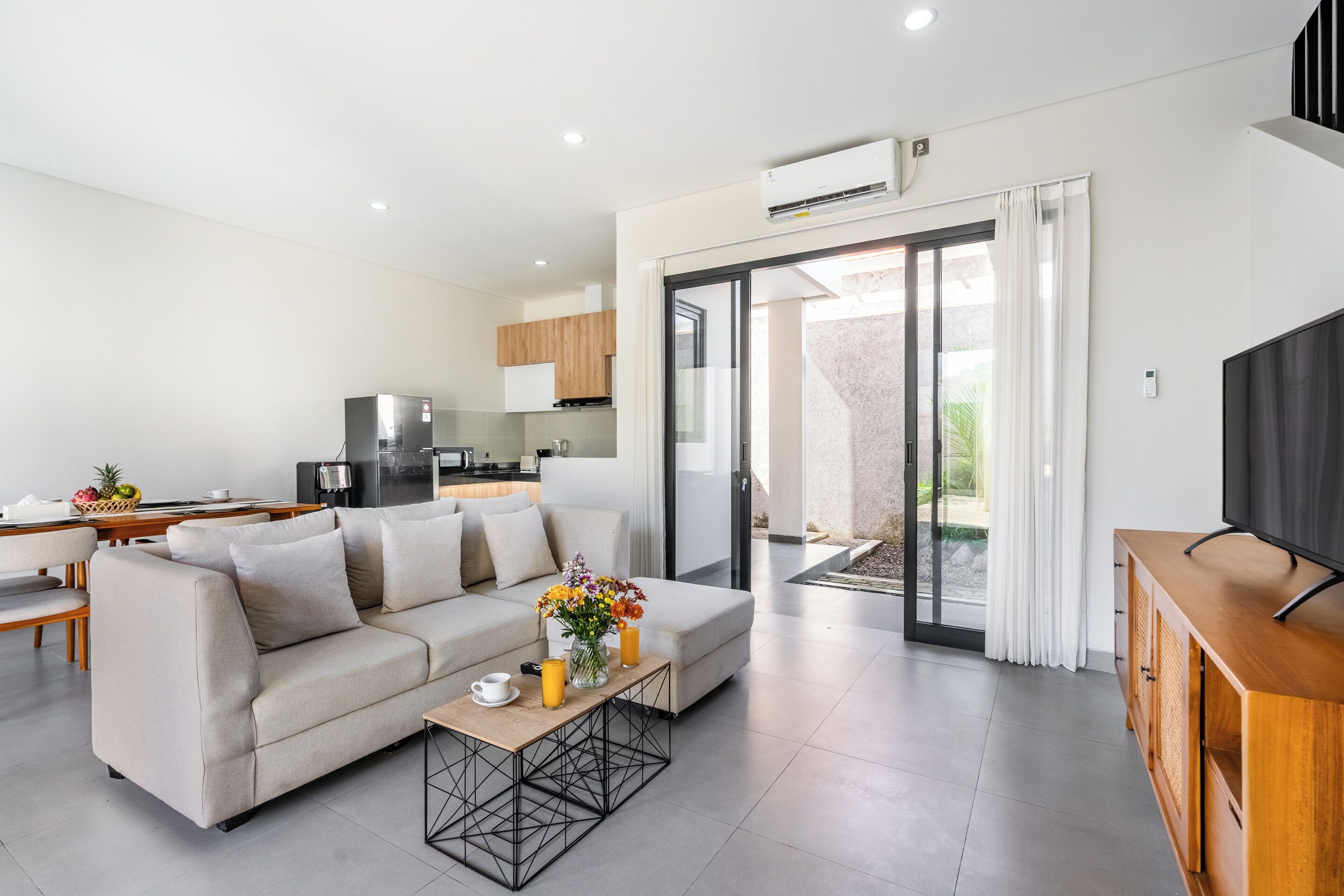 A modern living room with a sofa, coffee table, and a TV stand.