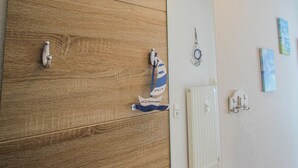 En sminkbord av trä med en spegel, en handduksställning och en handduk som hänger på den.
