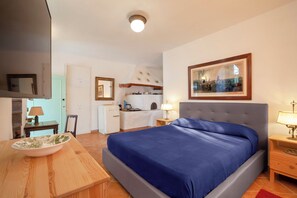 A bedroom with a bed, bedside tables, a desk, and a chair. - Gaiano APT (Sorrento)