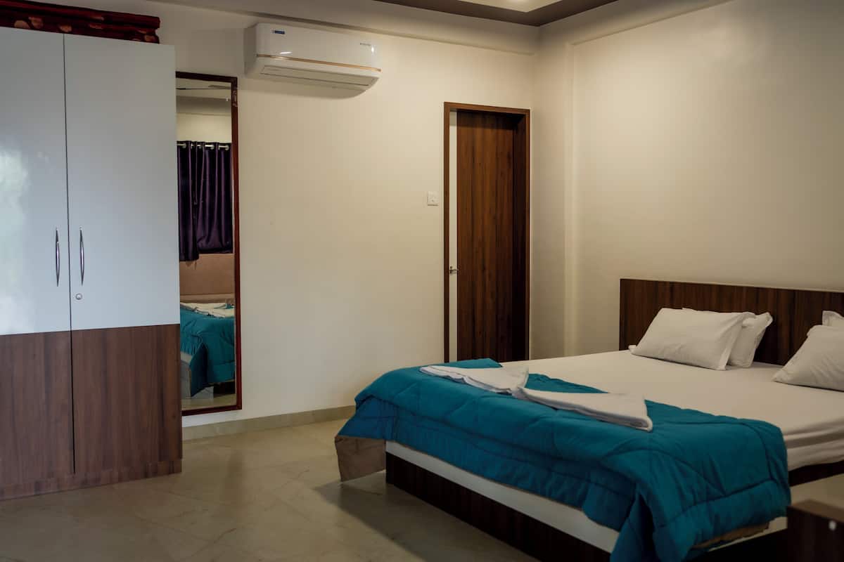 Una habitación de hotel con cama, armario y espejo.
