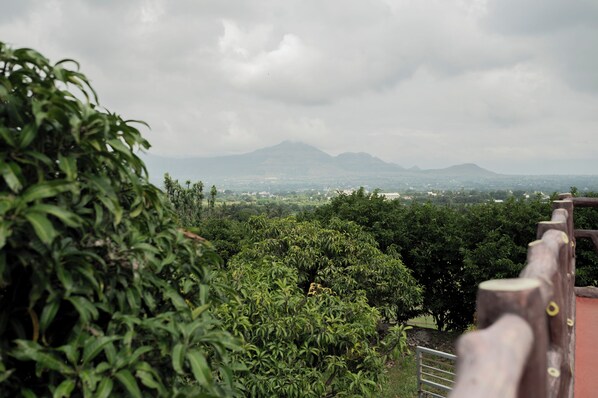 A view of a mountainous landscape with a wooden fence in the foreground. - Ambika Hills Resort (Junnar)