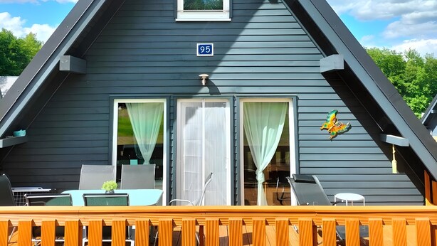 Un bâtiment triangulaire doté d’un balcon, d’une fenêtre et d’une porte.