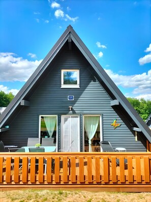 Un bâtiment triangulaire doté d’un balcon, d’une fenêtre et d’une porte.