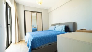 Una camera da letto con un letto, un comodino, uno specchio e una porta.