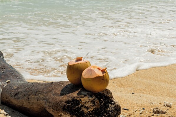 Two coconut drinks on a log by the beach. - Westwood Bungalow (Gili Trawangan)