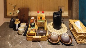 A traditional Japanese tea ceremony setup with a tatami mat, tea utensils, and a bamboo shelf with decorative items. - ZAO Hotel Firework & Sea View (Phu Quoc)
