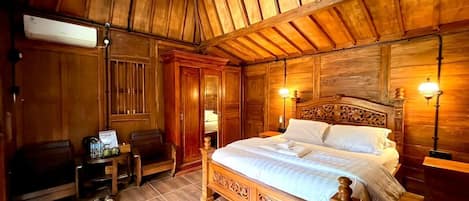A wooden-themed bedroom with a bed, bedside tables, and a bench.
