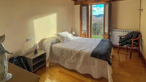 A bedroom with a bed, a chair, a desk, and a window with a view. - Casa Berrobiaenea  (Lana)