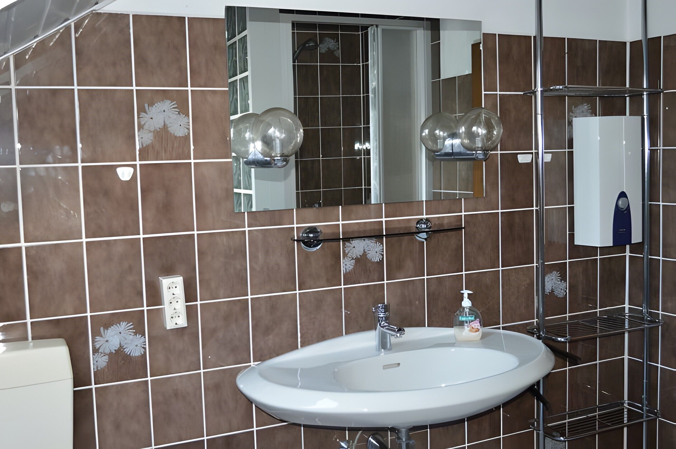 Ein Badezimmer mit einem weißen Waschbecken, einem Spiegel und einer Dusche.