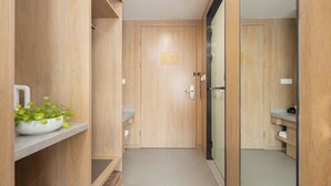 A modern bathroom with wooden cabinetry, a glass shower enclosure, and a small plant on a shelf. - Zhishang Hotel Hangzhou West Lake Zheyi  (Hangzhou)