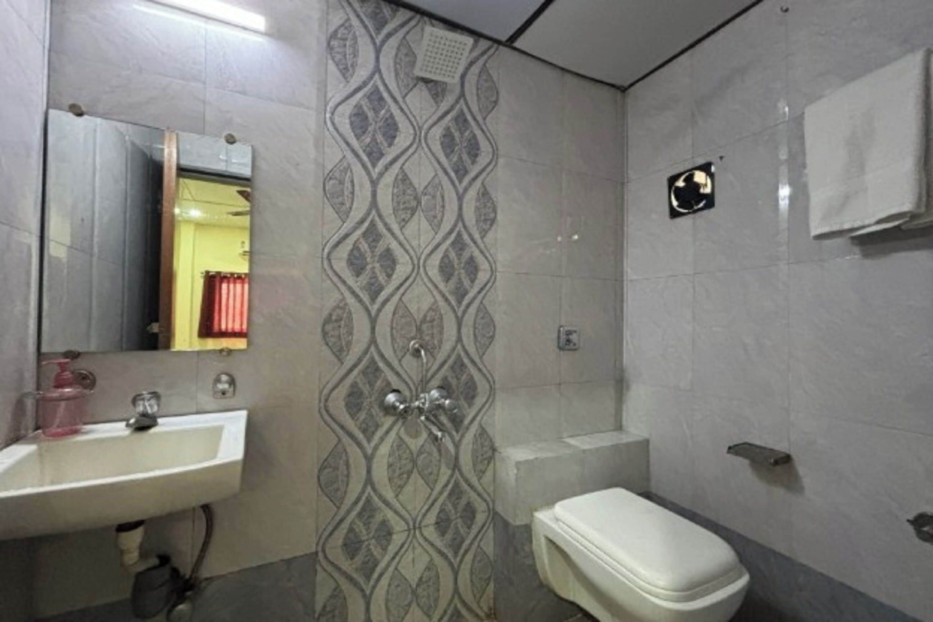 A bathroom with a white sink, a toilet, and a shower.