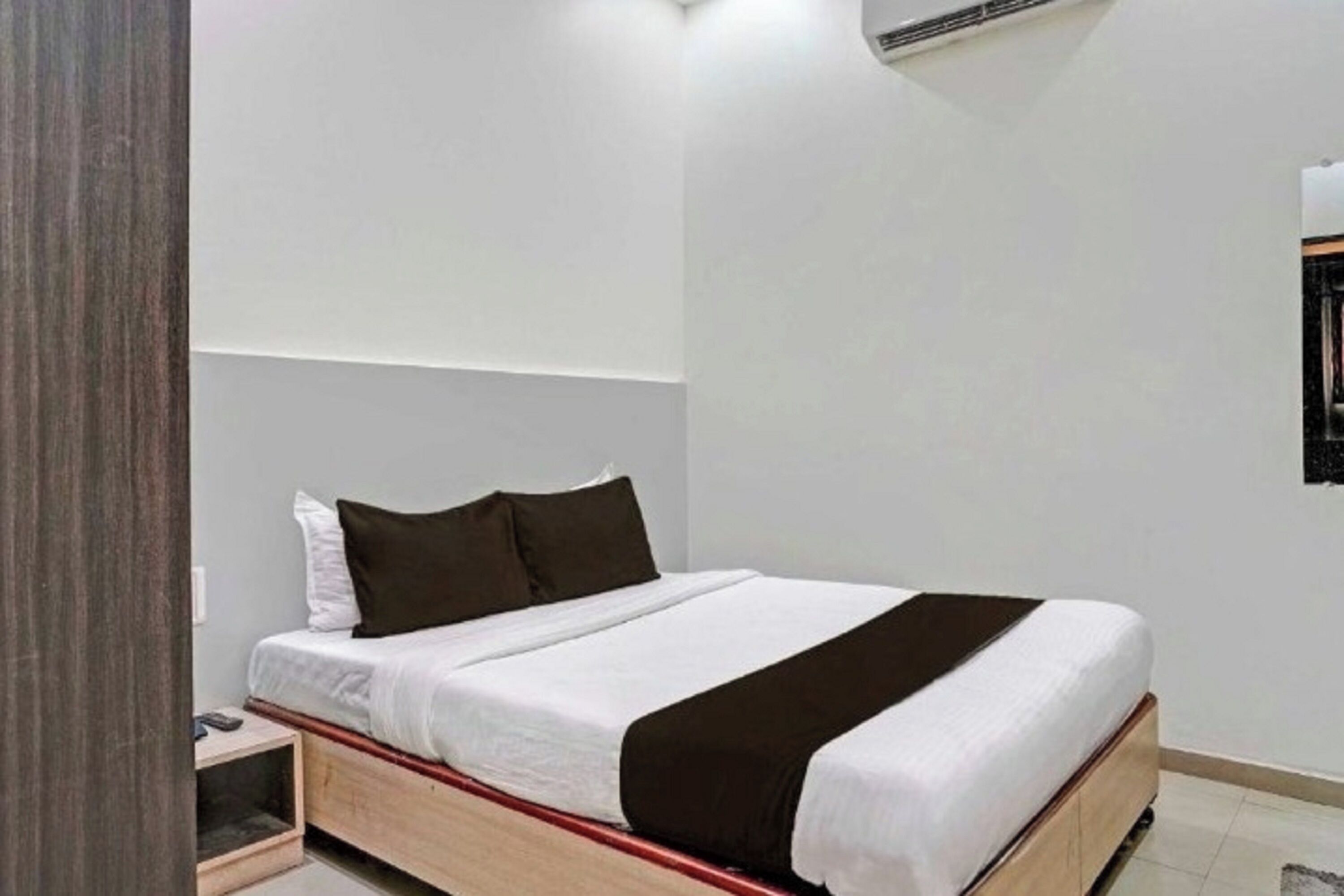 A modern bedroom with a single bed, a bedside table, and a nightstand.