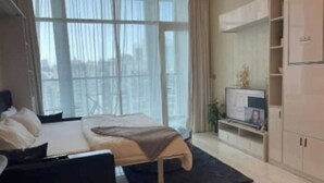Une chambre moderne avec un grand lit, une télévision et une armoire.