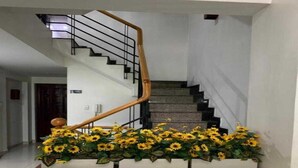 A staircase with a wooden handrail and a flower arrangement at the bottom. - Collection O Dinh Dinh Hotel - Near Tan Son Nhat Airport (Ho Chi Minh City)