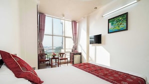 A hotel room with a large bed, a desk with a chair, a TV, and a window with curtains. - Collection O Dinh Dinh Hotel - Near Tan Son Nhat Airport (Ho Chi Minh City)