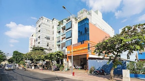 A multi-story building with a prominent orange sign for a hotel. - Collection O Dinh Dinh Hotel - Near Tan Son Nhat Airport (Ho Chi Minh City)