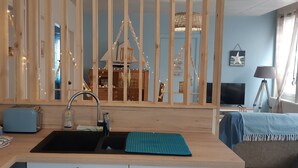 Et køkken med træbordplade, vask, brødrister og elkedel.