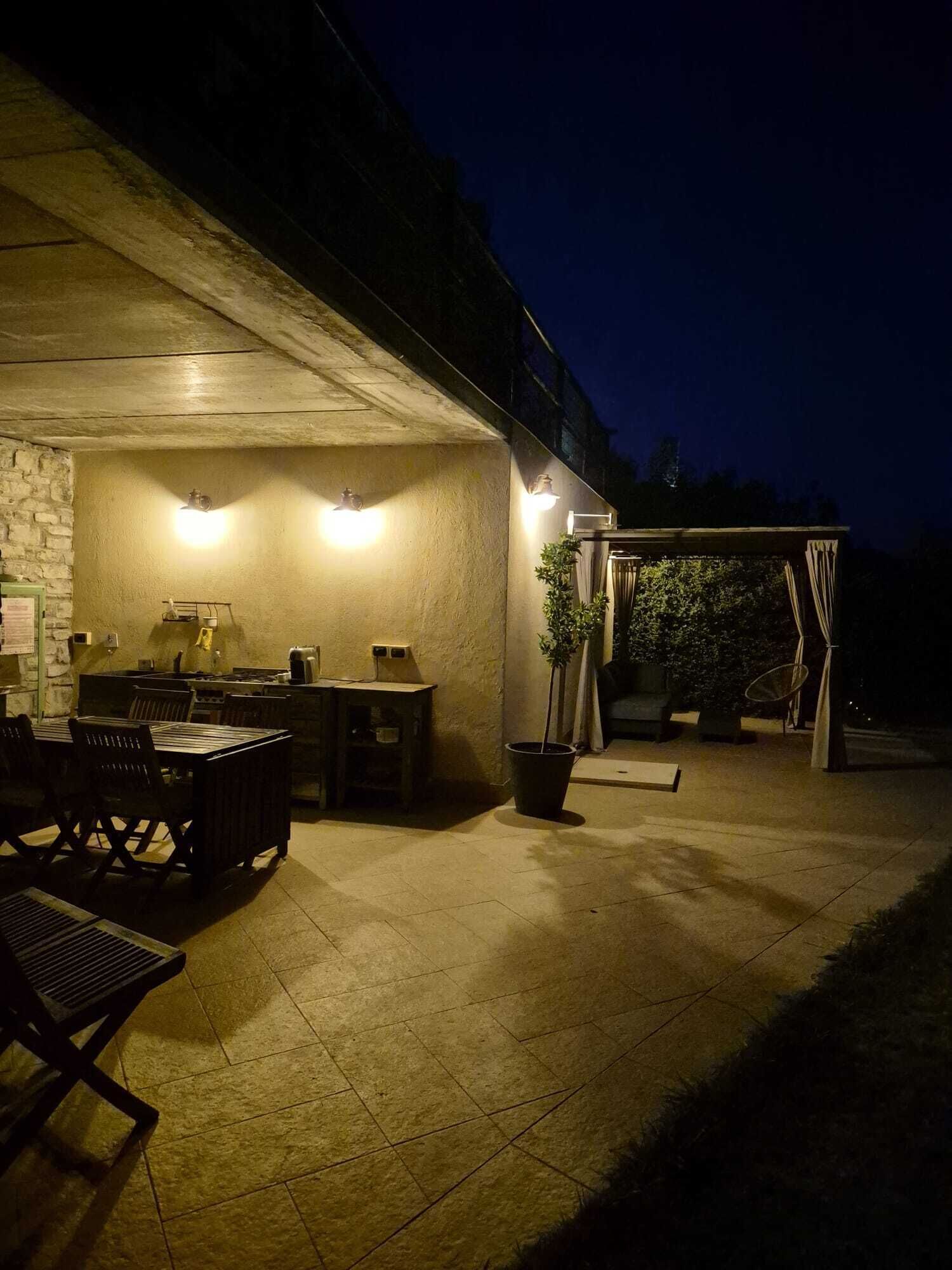 Un patio al aire libre con piso de concreto, una mesa de comedor con sillas y una planta en maceta.