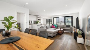 Un espacio de estar moderno con comedor, un conjunto de sofás y una cocina.