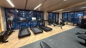 A gym with treadmills, elliptical machines, and weight benches. - Azizi  405 Fully Furnished Apartment (Dubai)