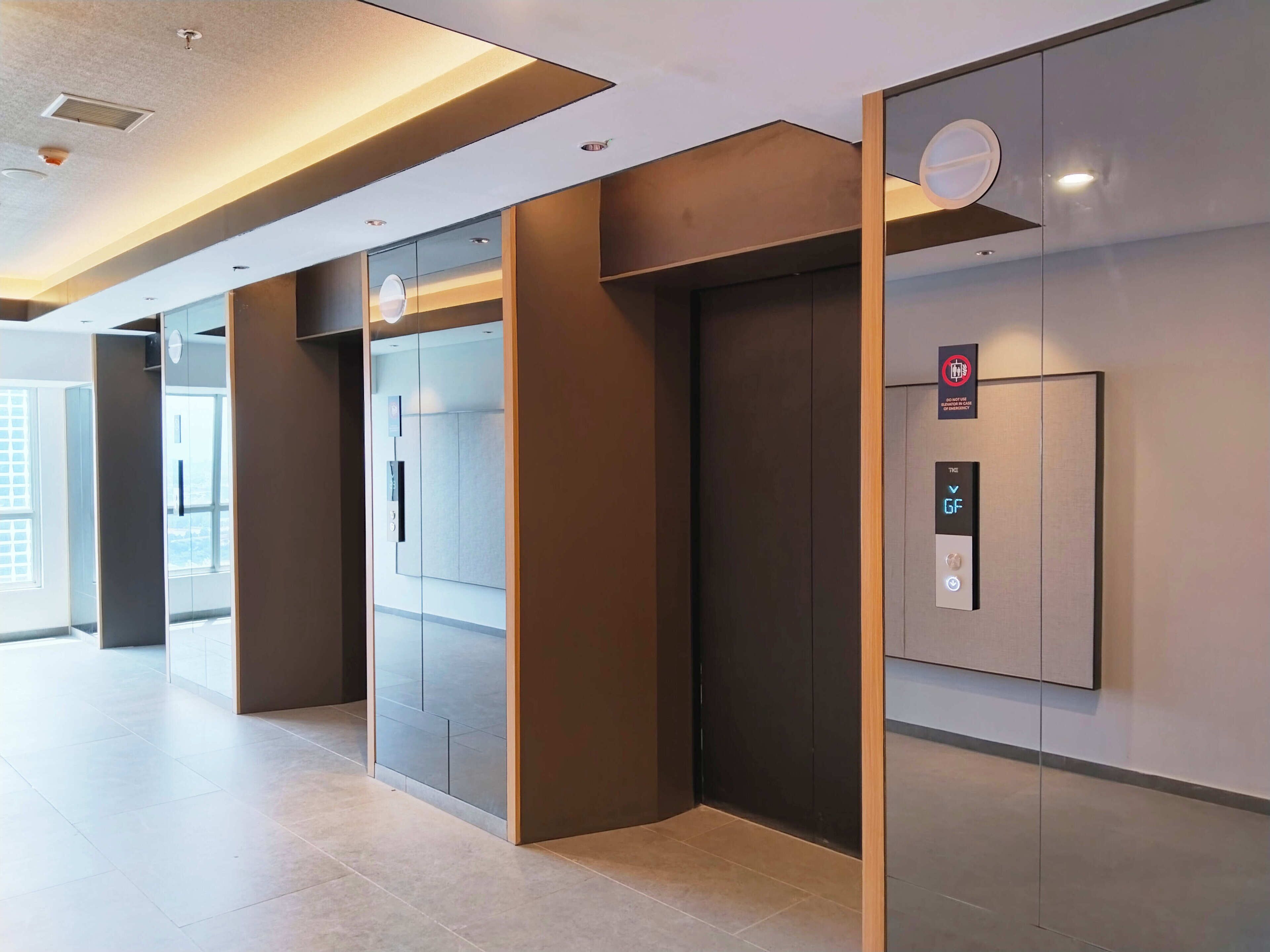 A modern elevator with a digital display and emergency stop button.