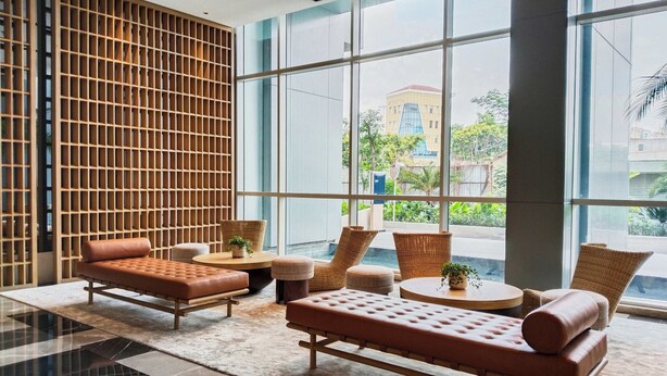 A modern lobby with a large window, a wooden partition, and comfortable seating. - 45 Antasari Suite powered by Cocotel (Jakarta)