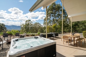 A hot tub with a view of the mountains, outdoor seating, and a pergola. - George's - Cabin 72 Kangaroo Valley Golf Course. Kangaroos, Wombats and Wildlife at your front door! (Kangaroo Valley)