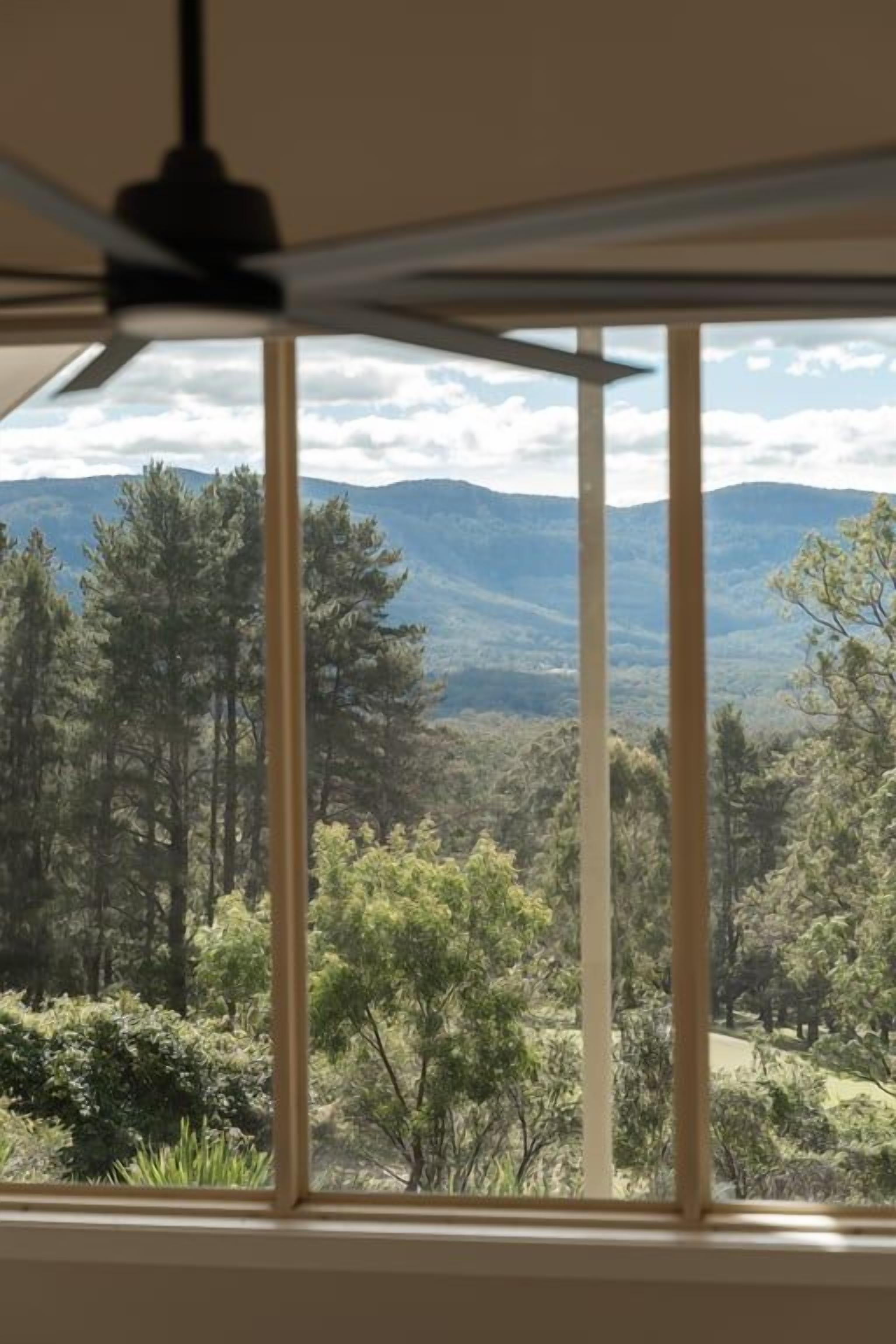 Une pièce avec vue sur un paysage montagneux, visible par la fenêtre.