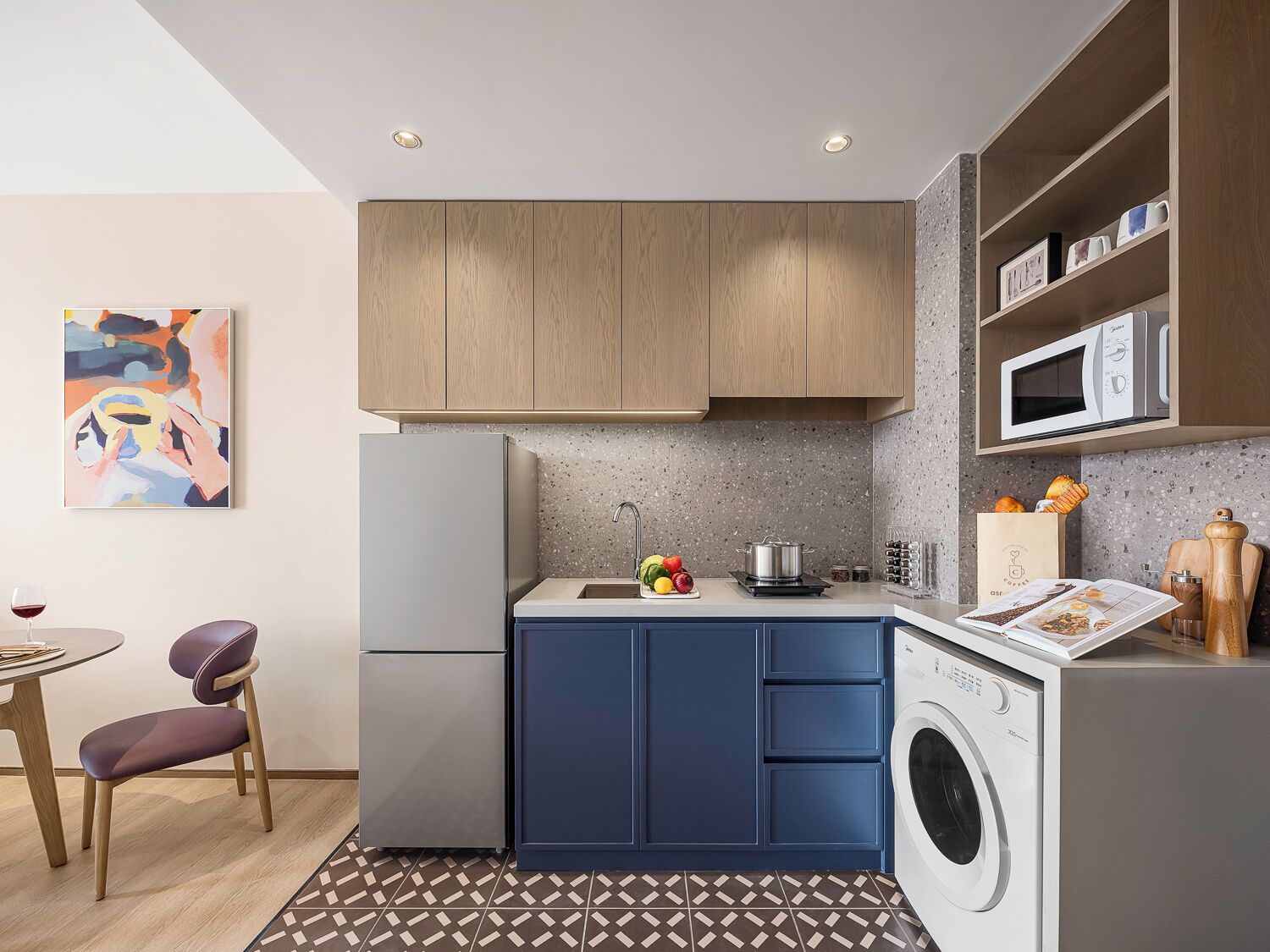 A compact kitchen with a washing machine, a microwave, and a sink.