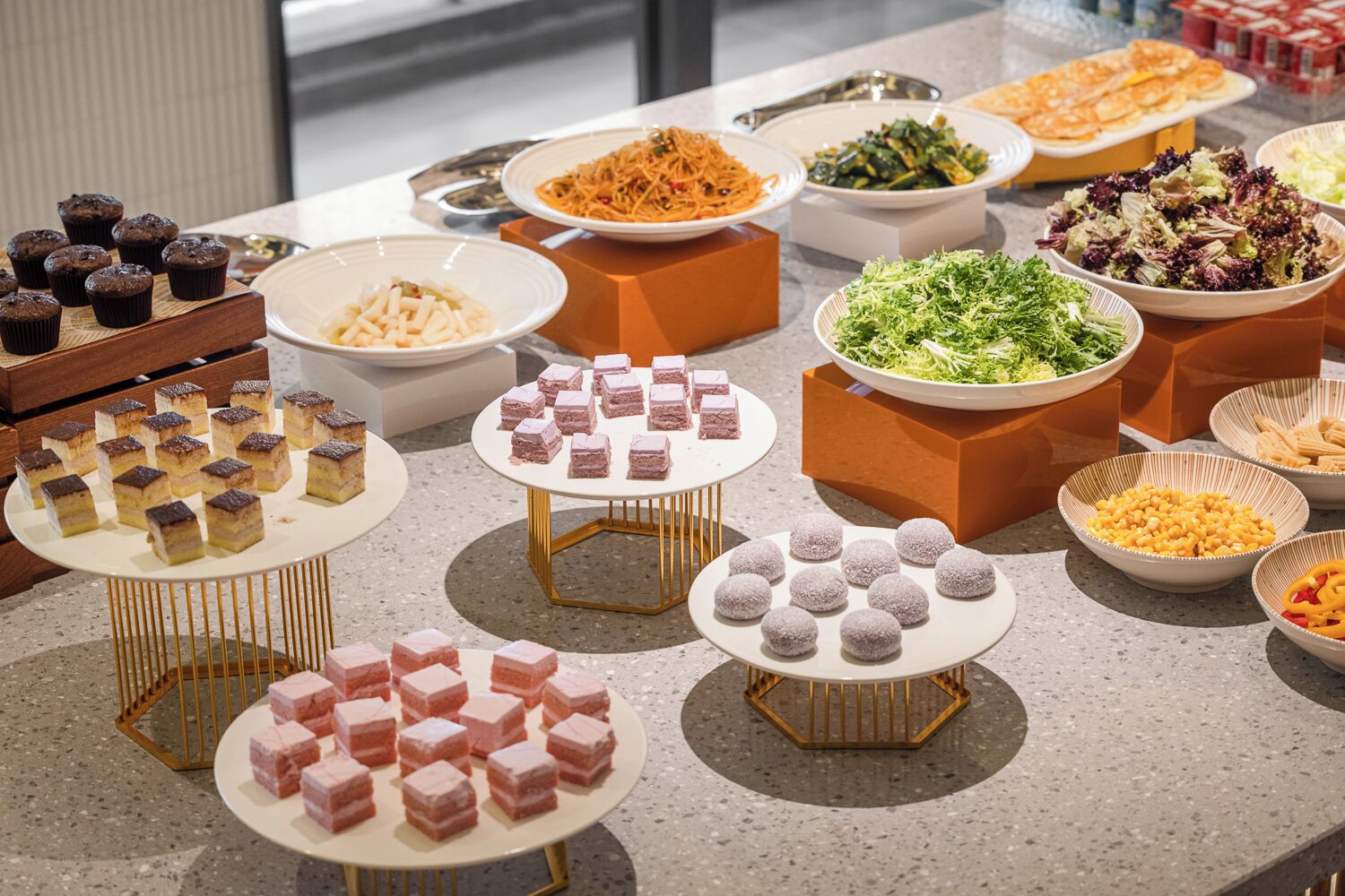 A buffet with various dishes including desserts and salads.