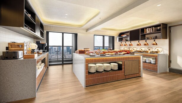 Una cocina moderna con una isla central, electrodomésticos integrados y vistas a la ciudad.