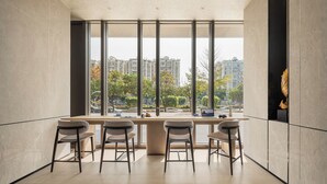 Un interior moderno con un ventanal grande, una mesa de madera y tres sillas.