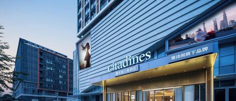 A modern hotel with a prominent 'citadines' sign, large windows, and a clean, contemporary design.