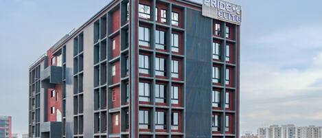 Un edificio de varios pisos con un letrero llamativo que dice "PRIDE ELITE".