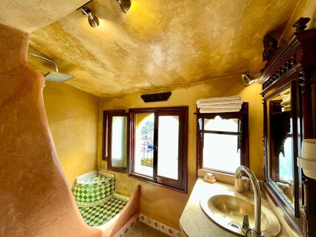 A bathroom with a checkered floor, a sink, and a shower.