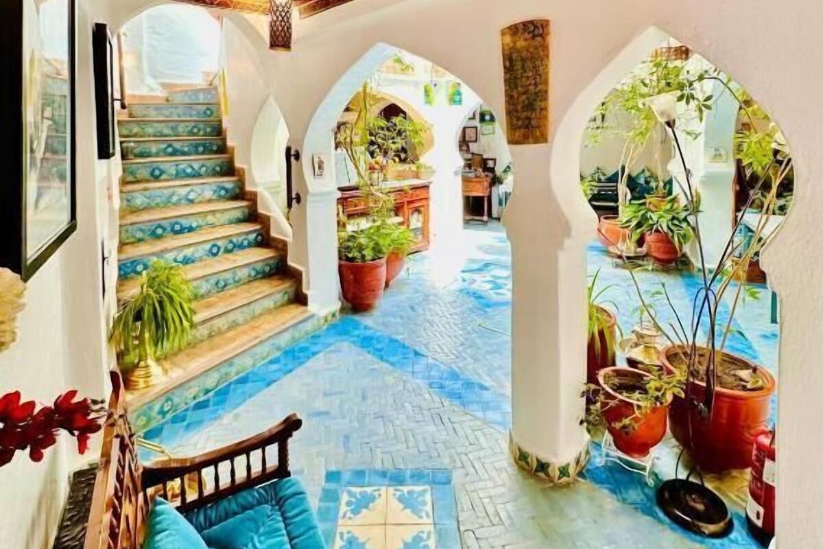 A spacious interior with a patterned floor, a staircase, and multiple arches.
