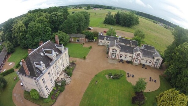 An aerial view of a large estate with multiple buildings, a well-maintained lawn, and a driveway leading to the main entrance. - Château de Bel Air (Cérans-Foulletourte)