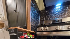 A kitchen with a stainless steel stove, a spice rack, and a wooden countertop. - Phenomenal 2-bedroom cabin in Saint Helen, the heart of northern Michigan. (St. Helen)