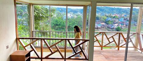 A room with a large window overlooking a residential area.