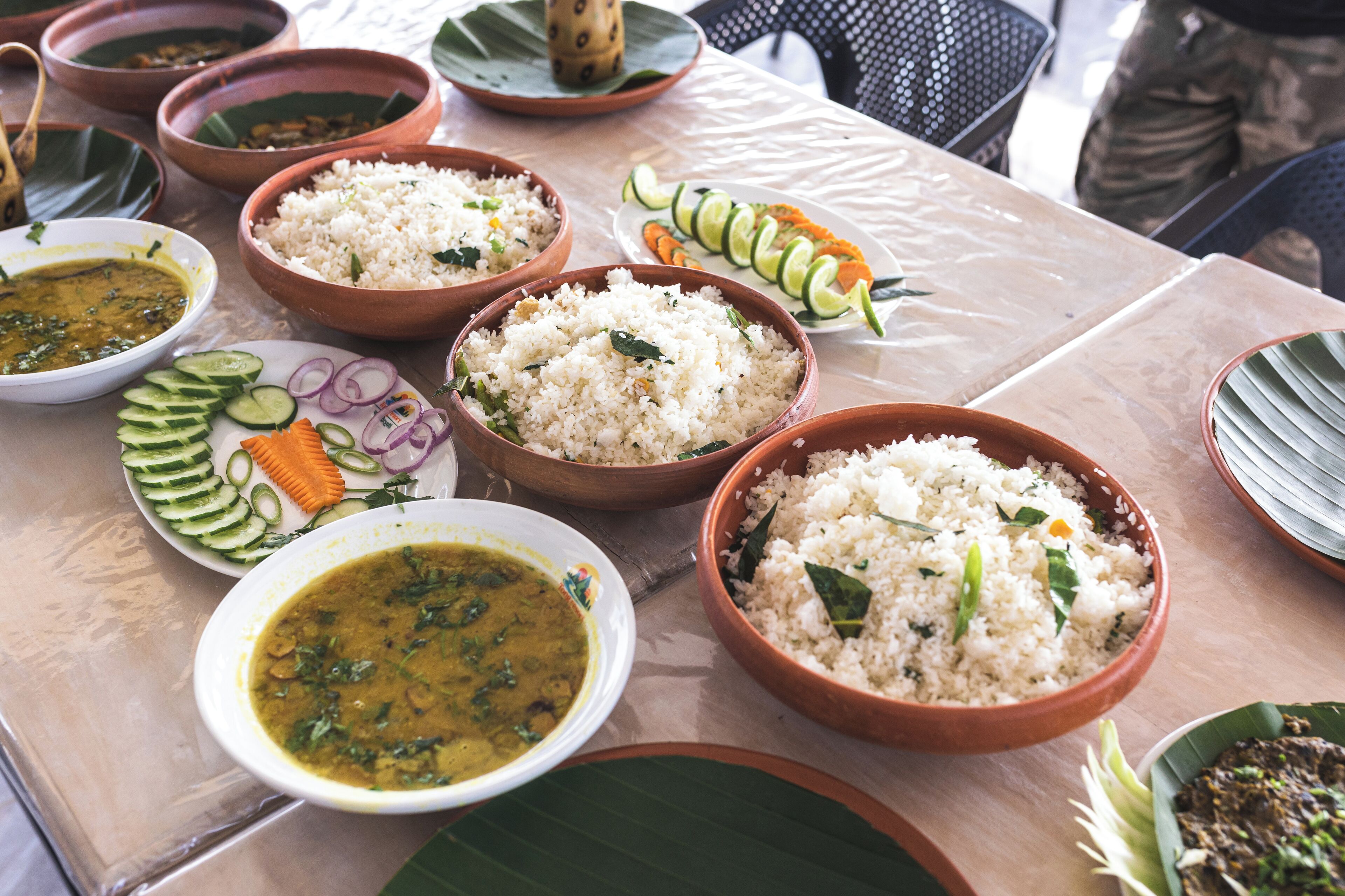 A table with various dishes including rice, curry, and vegetables.